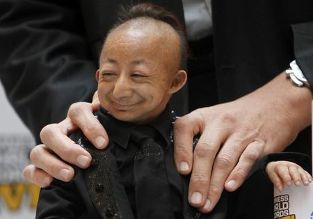 Хе народився в 1988 році в Китаї з так званої вродженої карликовостью, офіційно звання найменшої людини йому було присвоєно в 2008 році
